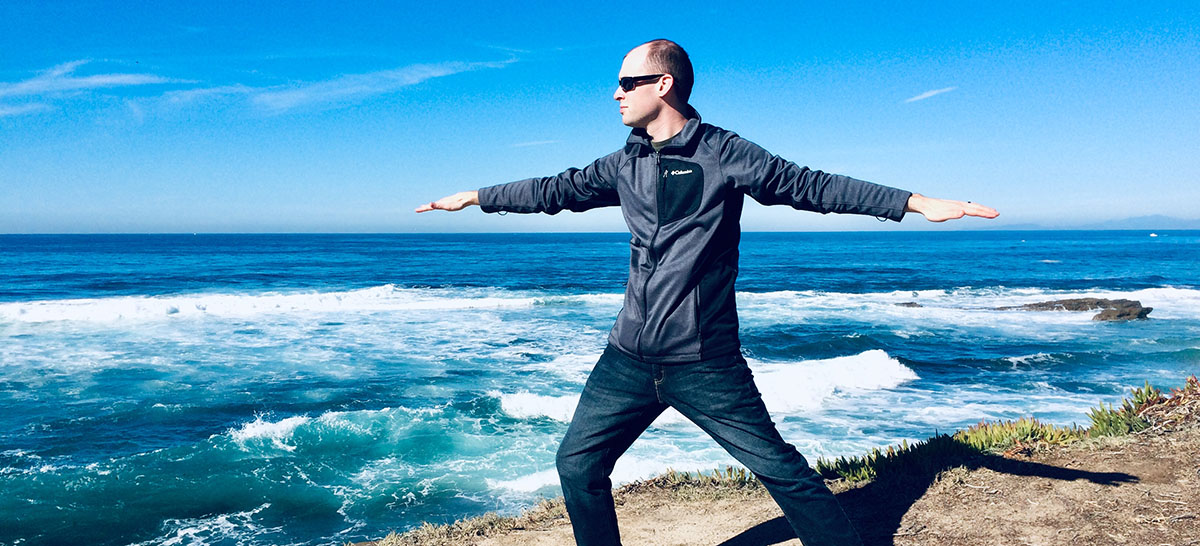 Jacob doing yoga by the ocean.