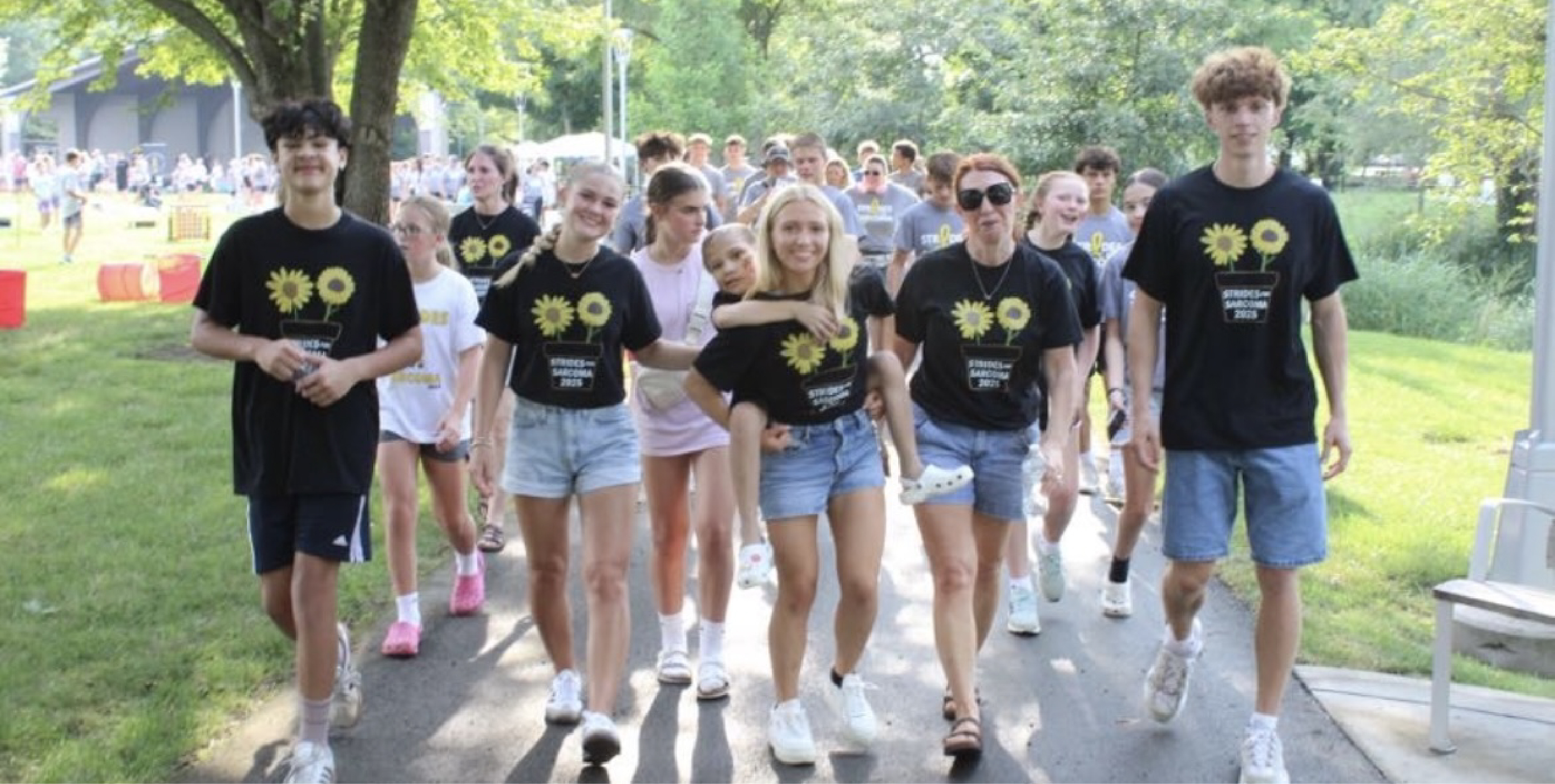 Gabriella Conjelko giving her cousin Maia a piggyback ride while walking with others