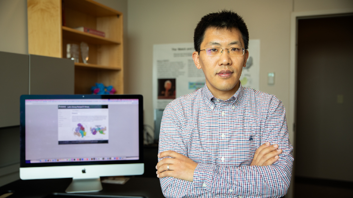 Leifu Chang stands in his office with computer models in background