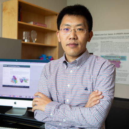 Leifu Chang stands in his office with computer models in background